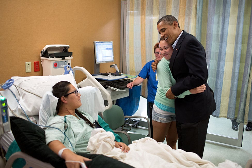 "The President hugs Stephanie Davies, who helped her friend, Allie Young, left, stay alive after she was shot during the movie theater shootings in Aurora, Colo. The President visited patients and fam