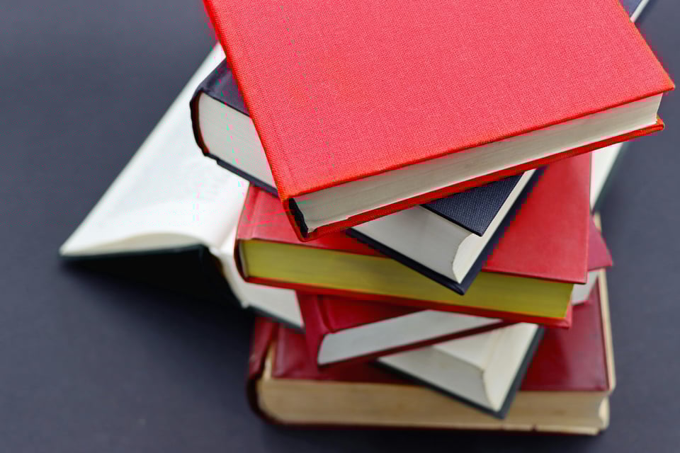 A colorful stack of books on a dark background.