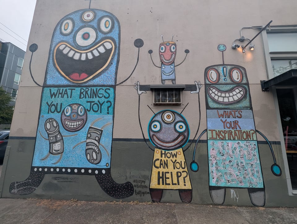 Robot street art shows robots saying WHAT BRINGS YOU JOY? and HOW CAN YOU HELP? and WHAT'S YOUR INSPIRATION? Cute and tons of eyes and smiles.