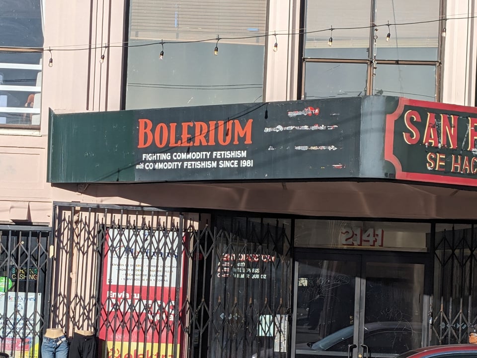 A photo of the Bolerium on Mission St in San Francisco. The sign reads: "FIGHTING COMMODITY FETISHISM WITH COMMODITY FETISHISM SINCE 1981"