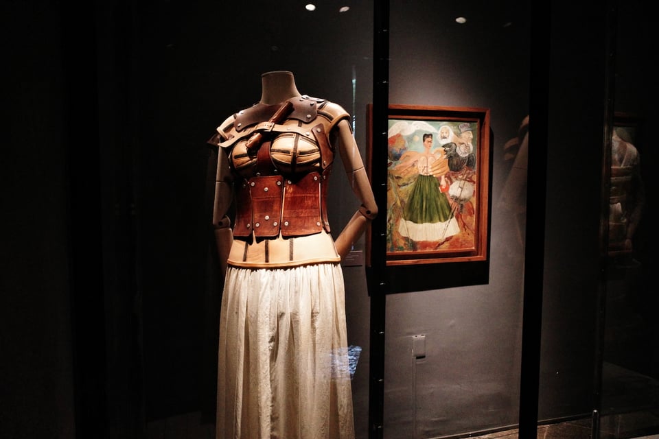 Kahlo garments, with the above-mentioned “Marxism Will Give Health to the Sick” hanging in the background, at Casa Azul.