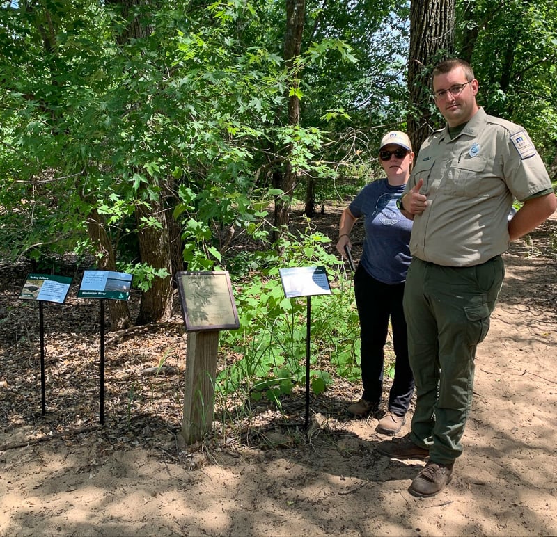 Park manager Jake Gaster and assistant manager Amy Jay placed the new signs along the Sand Point Trail. / Photo by Janet Malotky