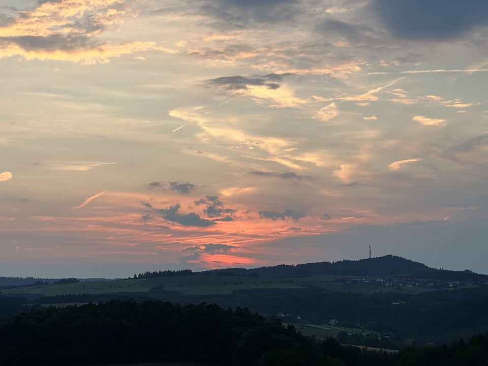 Photo of a sunset over a hill