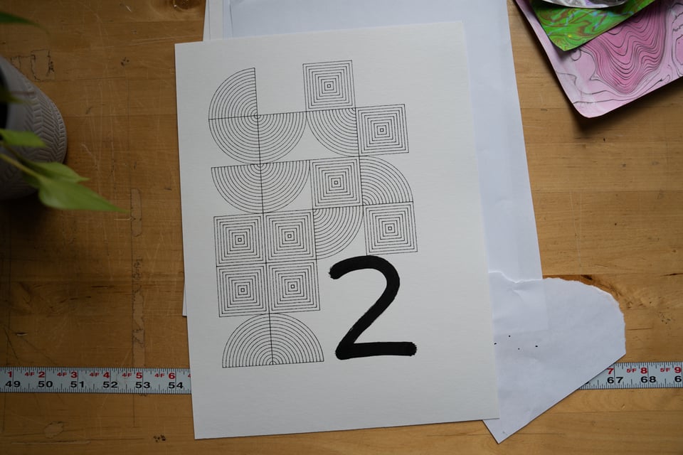 A number 2 on a flier filled with abstract shapes.