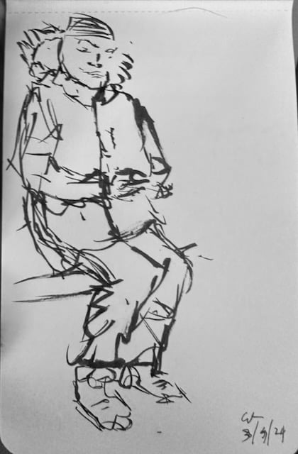 Photo of a brush-pen drawing of a man in sweatpants sitting on the subway