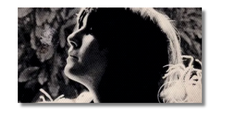 Cropped image from the cover of Eve's Hollywood by Eve Babitz, showing the author in profile, wearing a feather boa