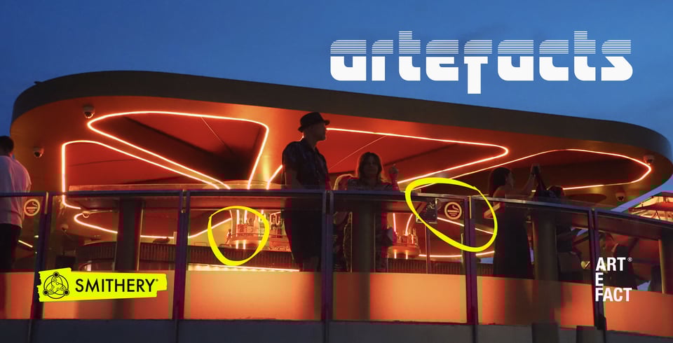 A man and a women standing in an illuminated orange bar with Artefacts title superimposed on top