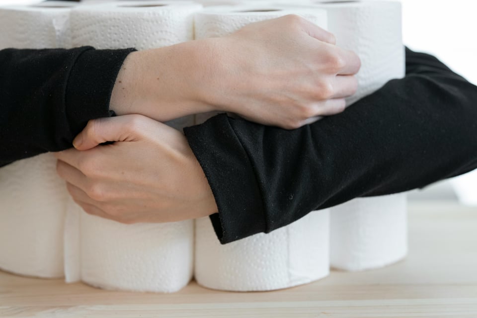Image of person clutching a large pile of toilet paper.