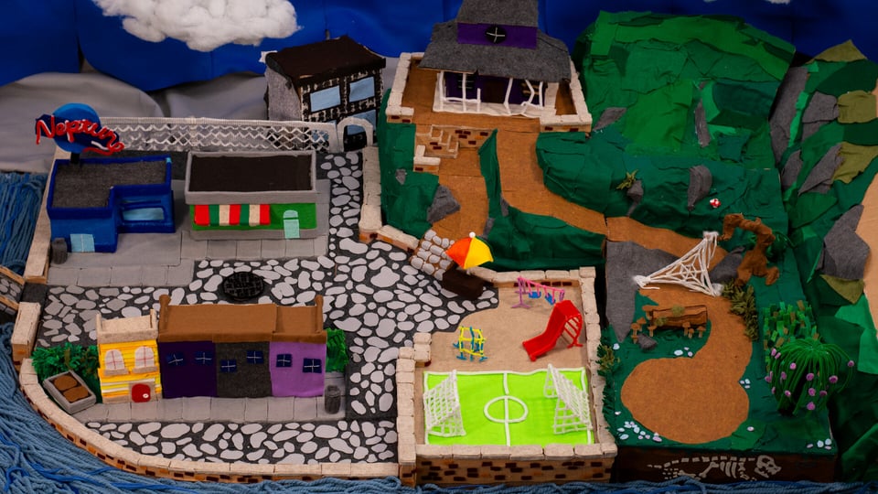 An isometric view of a handcrafted town, made with wire and fibre and felt and clay.