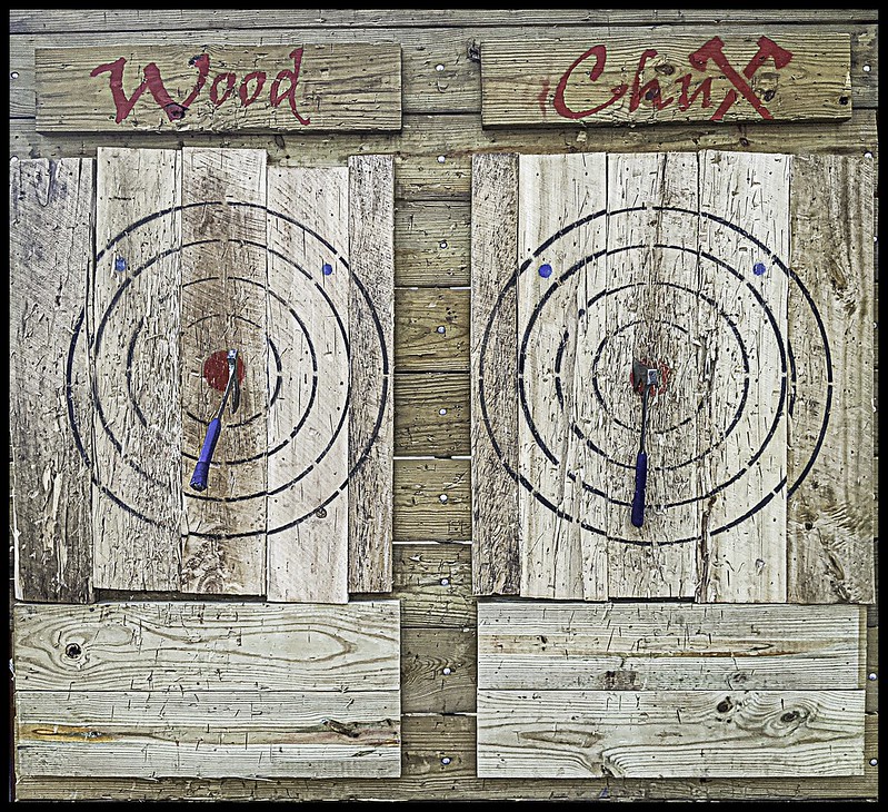 a pair of wooden targets with axes in each