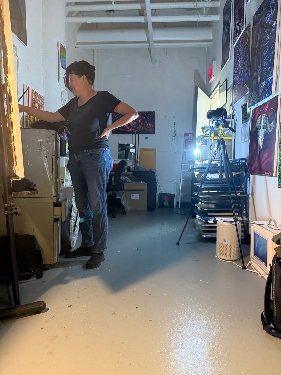 Photo of Janet in its studio standing smiling and mixing paint