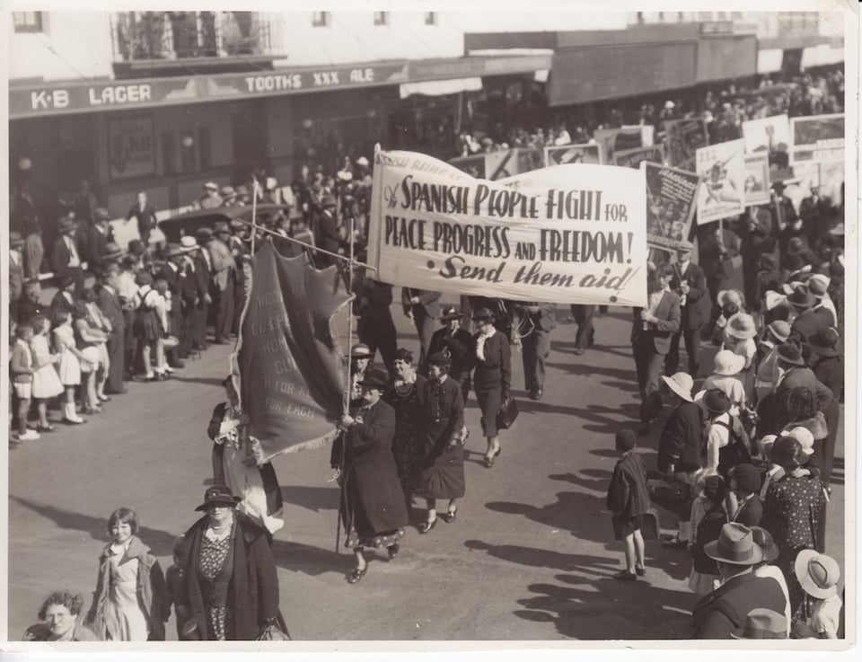 Photograph of May Day march in 1937 featuring banner "Spanish People Fight for Peace, Progress and Freedom! Send them aid"