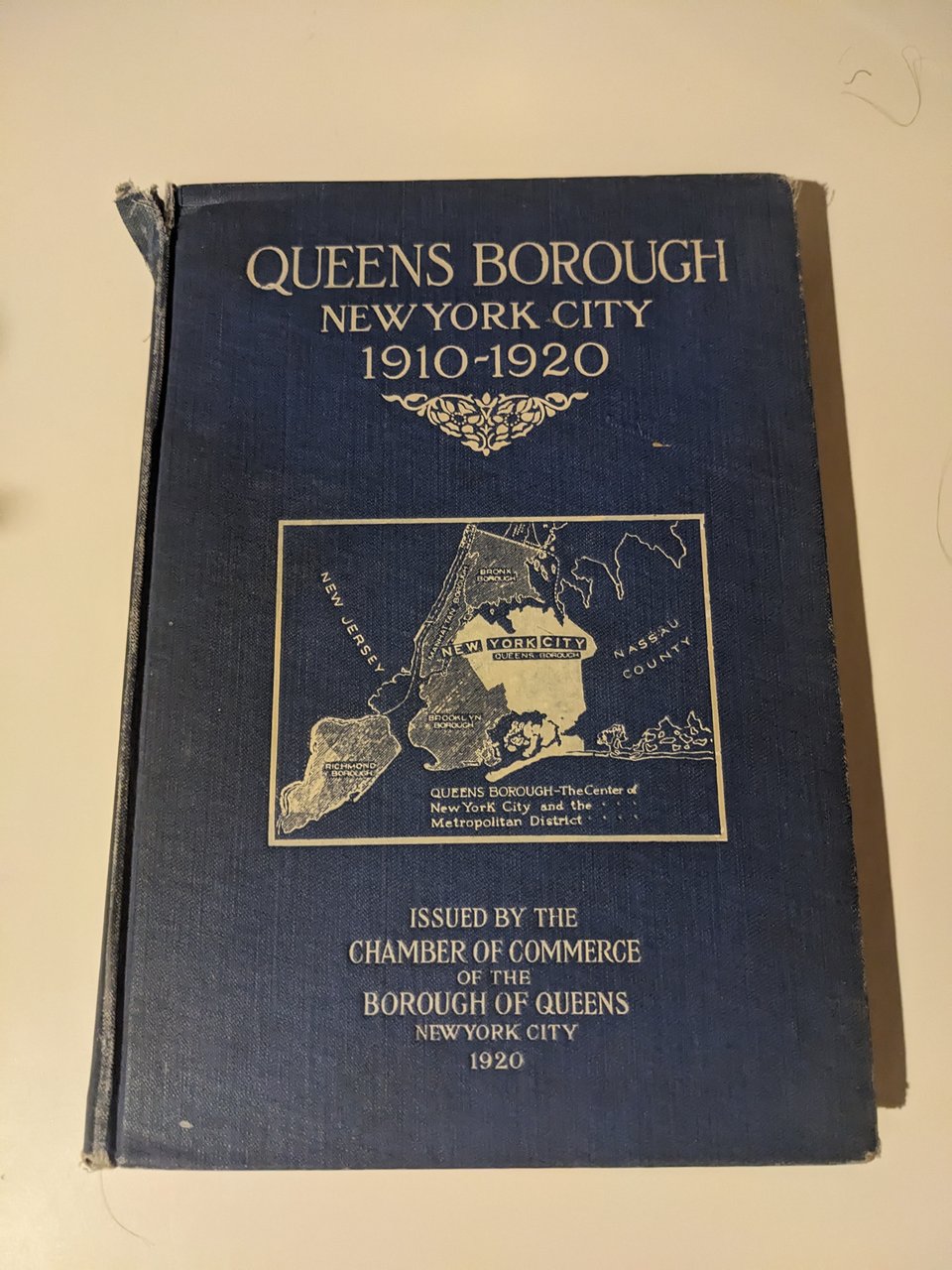 A blue cover with white text and a map of New York City with the borough of Queens highlighted in white.