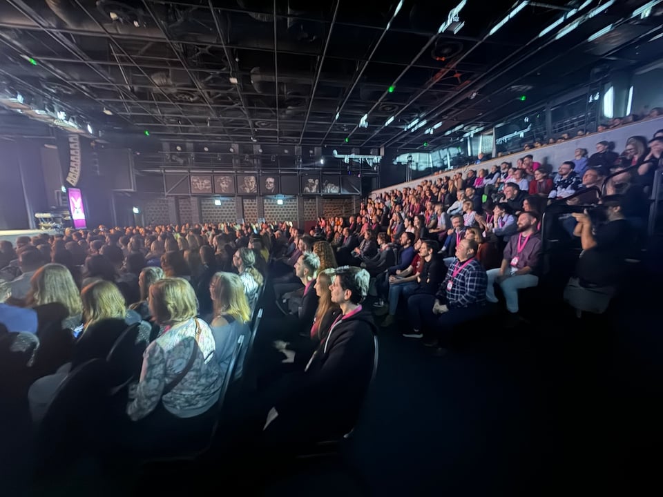 A packed room of people watching improv.