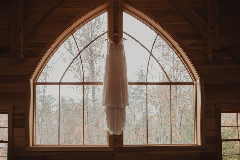 a wedding dress hanging in a window