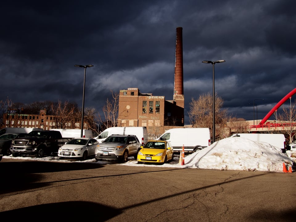 Landscape photo with an old smokestack against an ominous dark sky