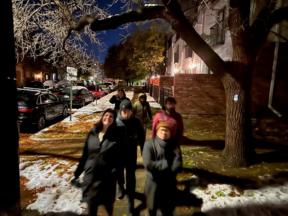 A group of people walking outside at night.