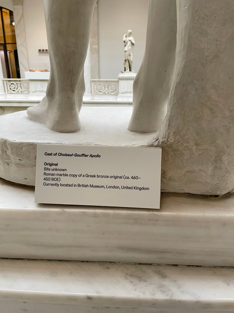 close up of a placard and the foot of a plaster cast sculpture