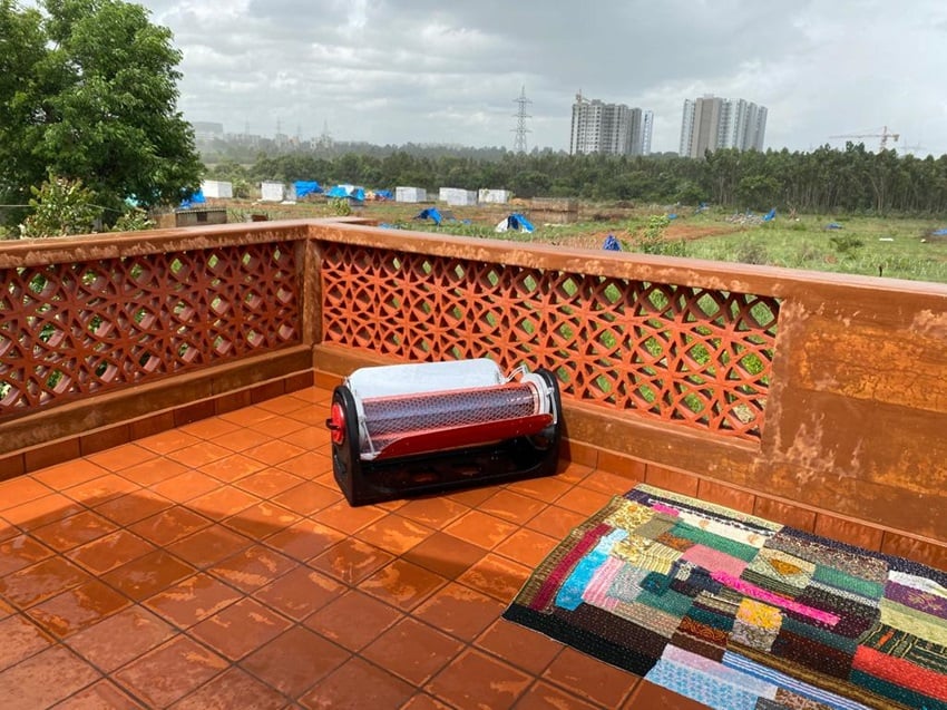 A solar heater next to a rug on a rooftop