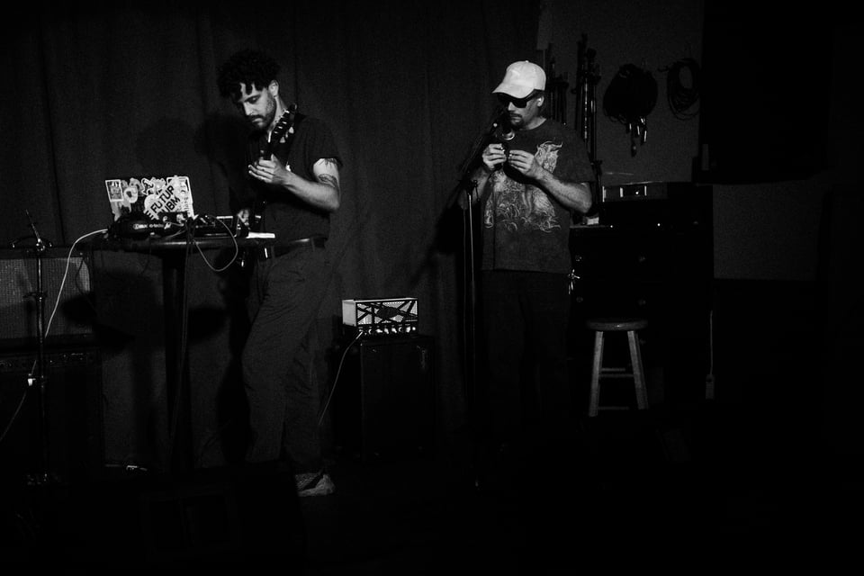 Ghost Down performing on guitar and laptop with Kenny H joining them, shaking baoding balls.