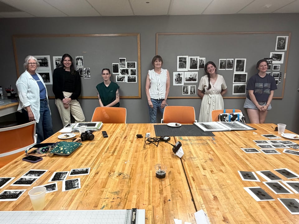 darkroom class standing in front of prints