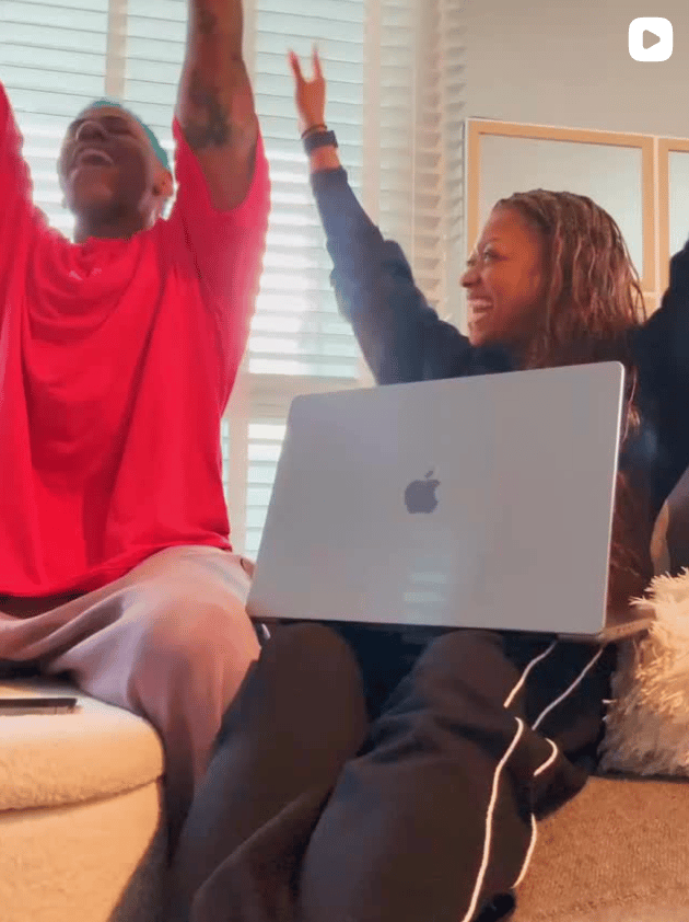 A short video of two people, including me, sitting on a couch with a laptop, celebrating with their arms raised.