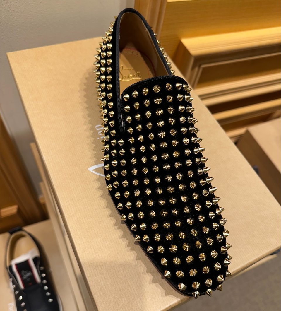 Photo of a black loafer that's covered in little silver spikes.