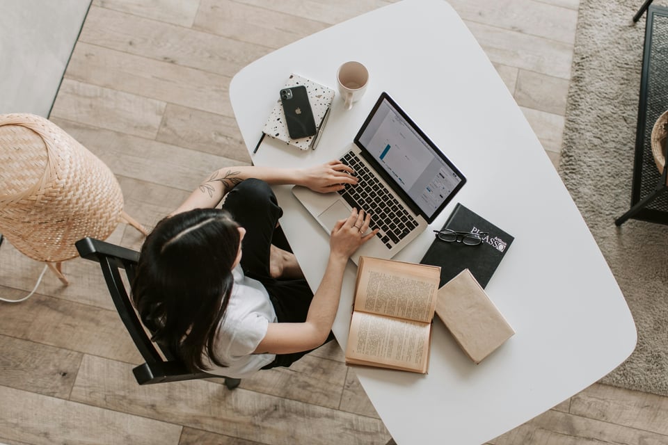 Stock image of a person typingat a desk.