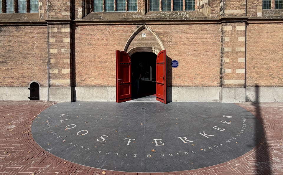 Entrance of the Kloosterkerk on a sunny evening. The Belgian bluestone semicircle shows which door is the main one. You see the lettering, and maybe, the careful observer will even see the "2" above the door.
