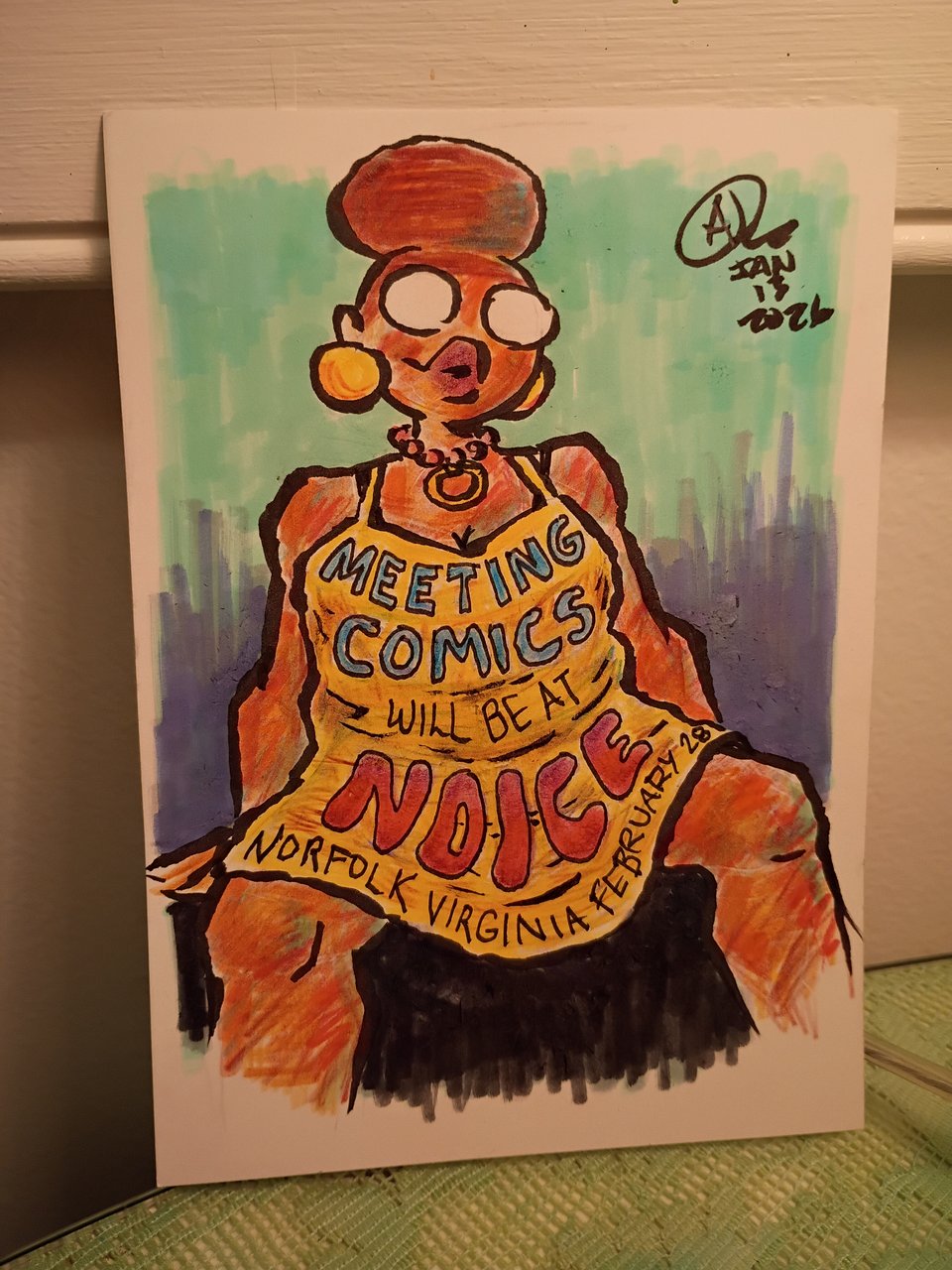 A drawing of Val and ink, colored pencil, and marker. She's wearing a dress which says on it: Meeting Comics will be at NOICE, Norfolk Virginia, February 28.