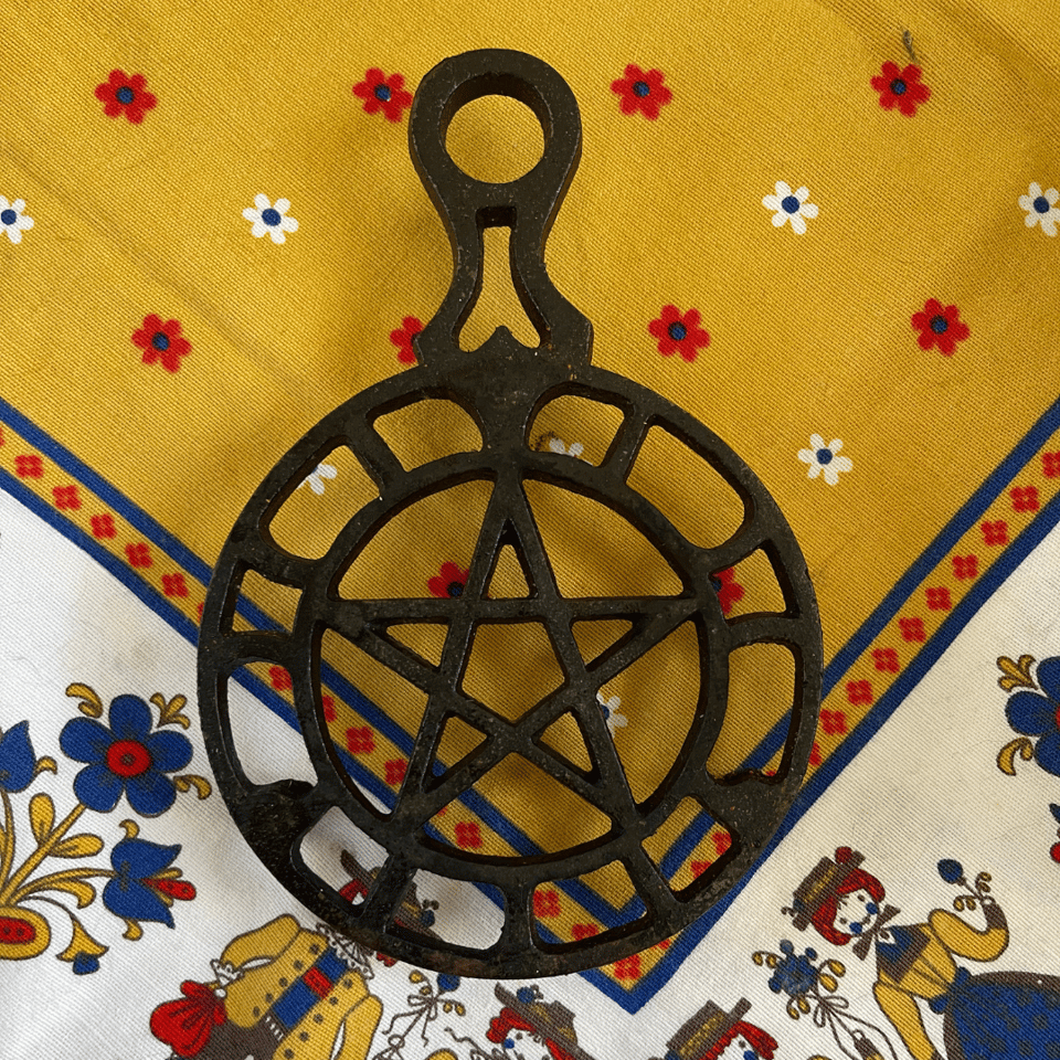A pentacle iron trivet on a Slovenian tablecloth