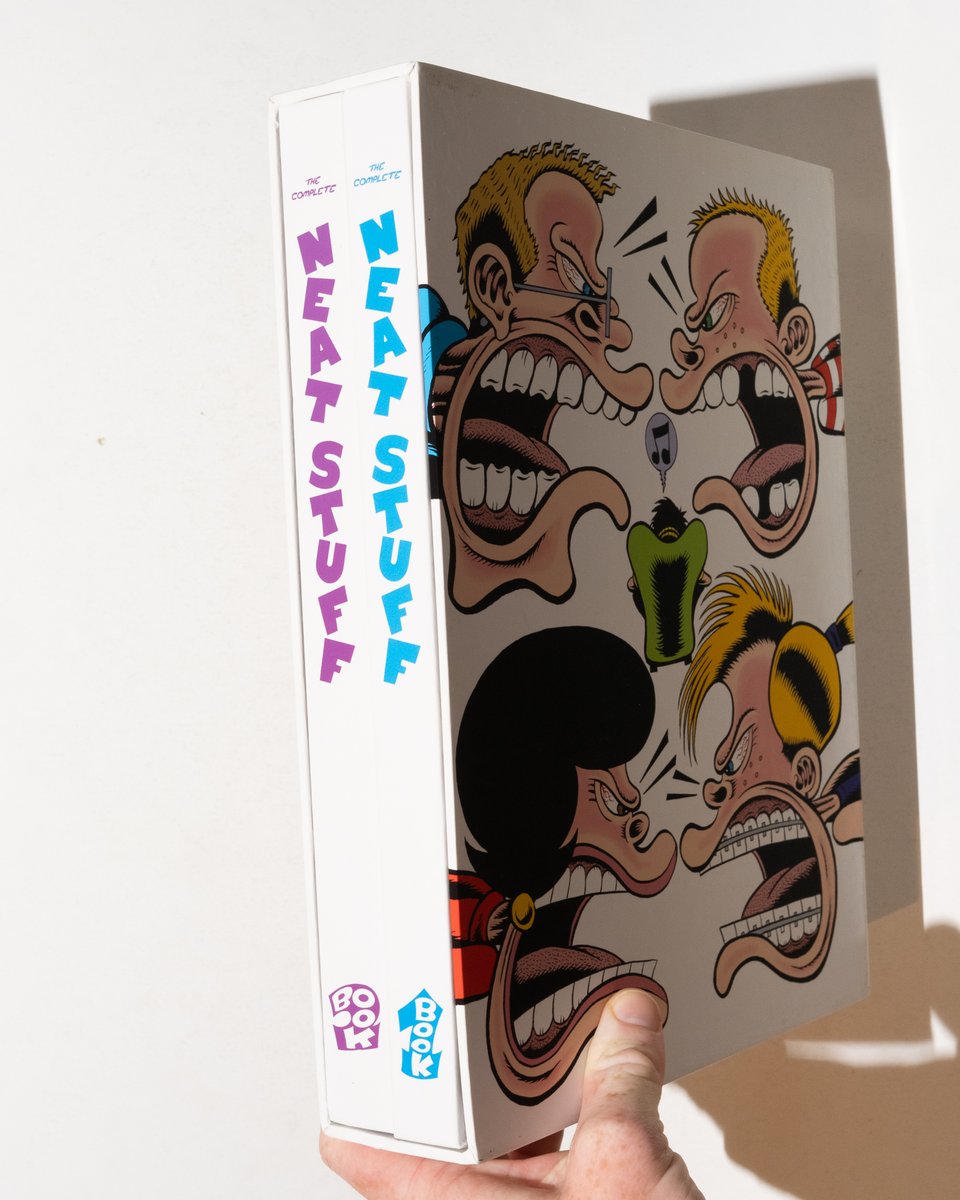 a hand holding "The Complete Neat Stuff" to show the two volumes in the slipcase