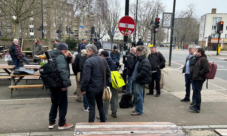 men with bags, hats and thick coats gather for some winter TTRPGs