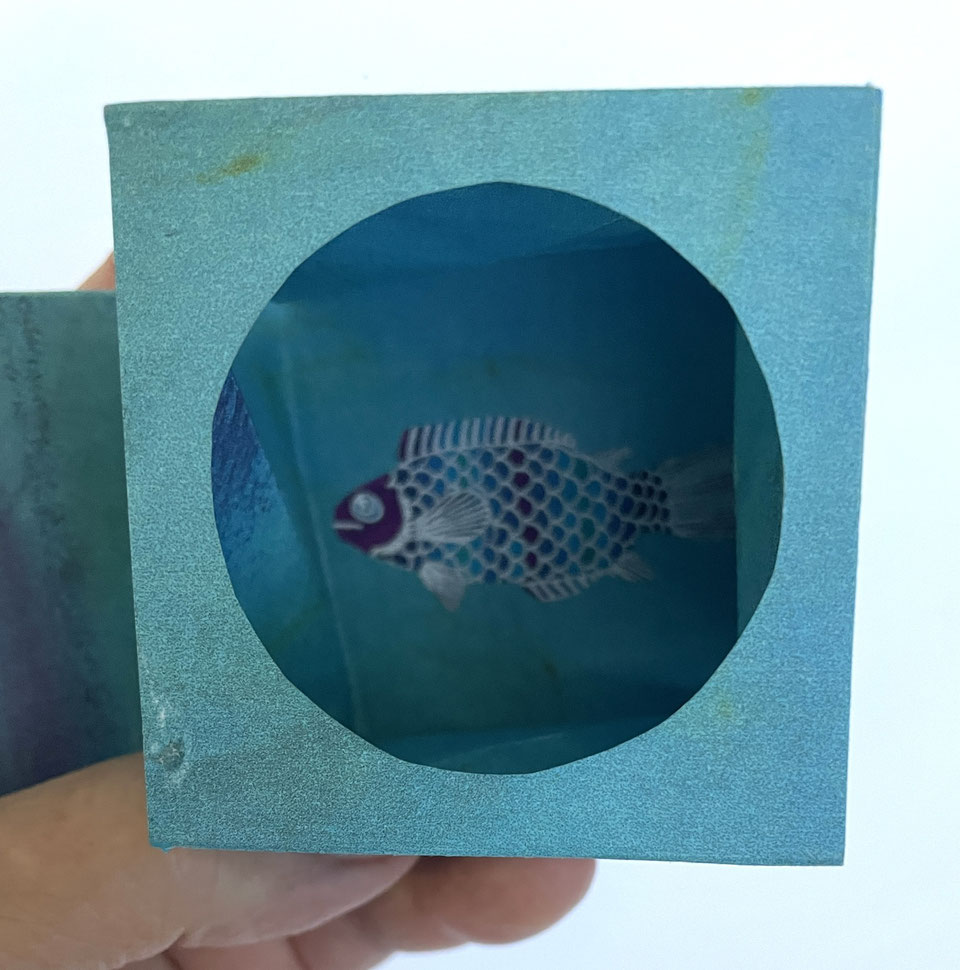 Le pliage ouvert, on distingue un poisson au fond