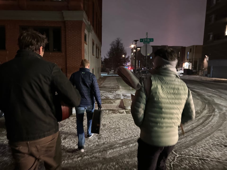 People carrying instruments in the cold.