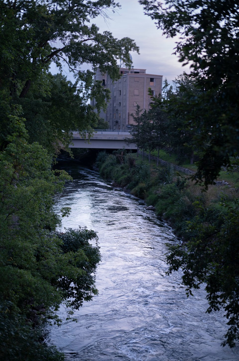 Image of a river, with an old brick grain silo in the background on one bank.