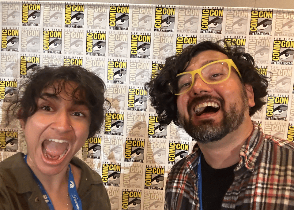 Rekha Shankar and Omar Najam in front of a San Diego Comic Con backdrop