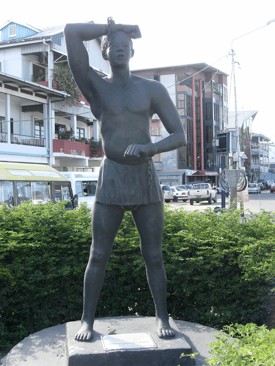 sculpture of a man in Surinamese maroon clothing with broken chains on wrists