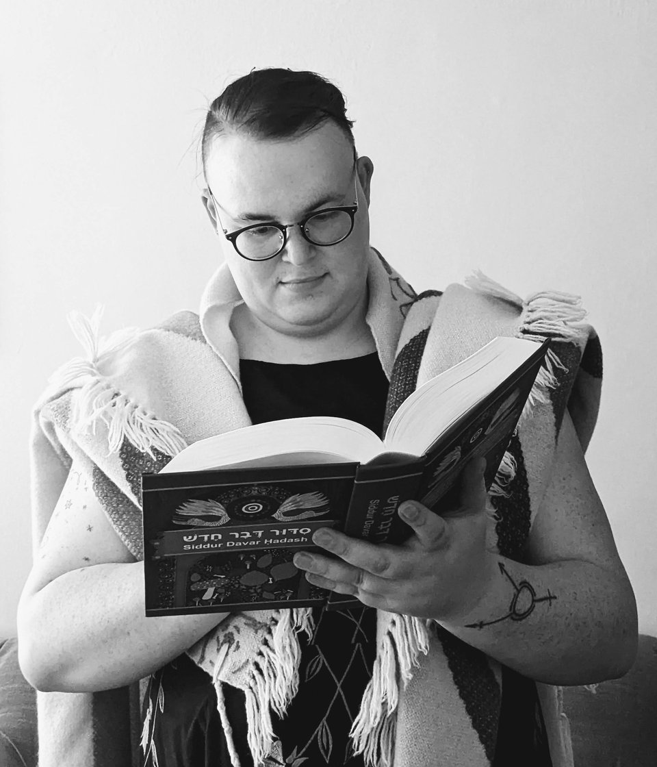 A black and white shot of me praying from the siddur while wearing a tallis.