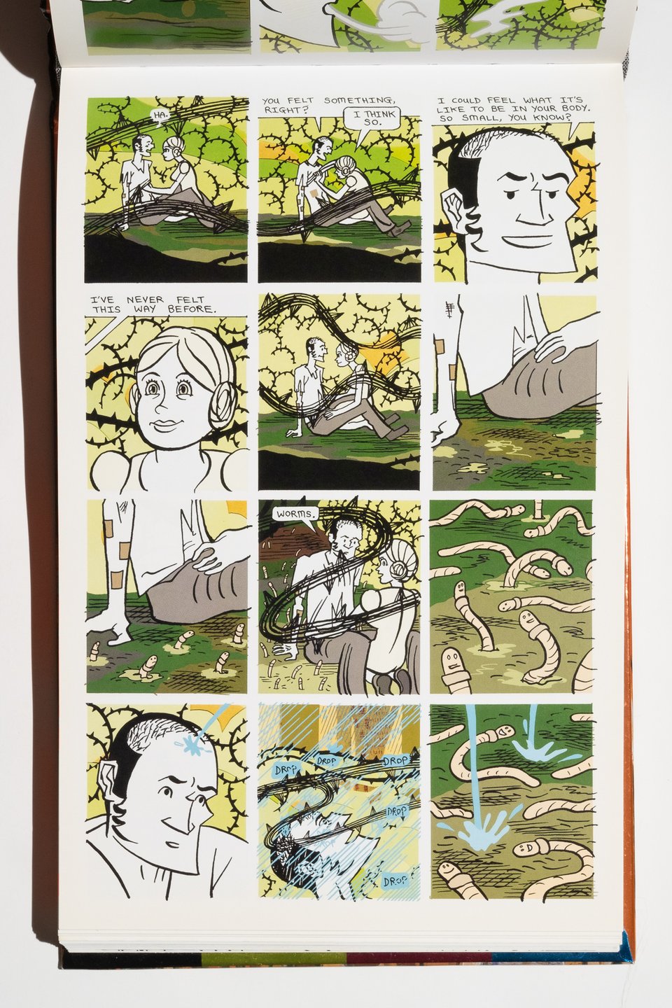 a page from Bodyworld. Two people have taken drugs and are sitting together outside as they take effect. This is represented through abstract black lines, rain falling, and worms with smiling faces