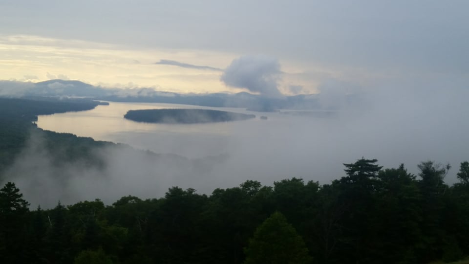 A mist-shrouded view of an island in Rangely Lake from The Height of the Land rest stop