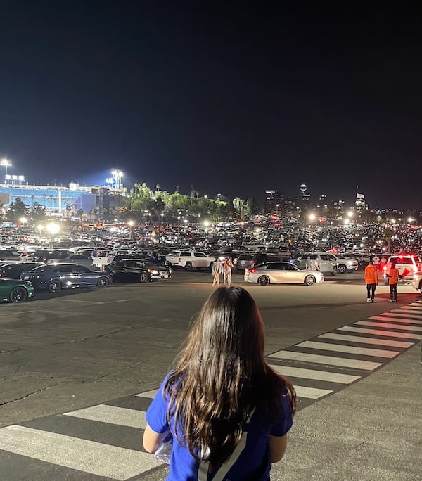 a girl standing in a parking lot at night