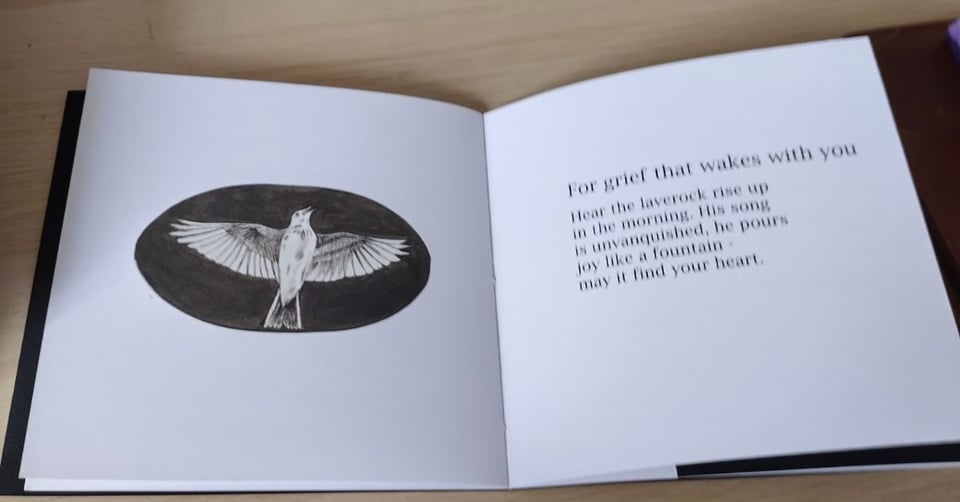 open book - on the left hand page a lark singing in flight on the right a short poem for grief that wakes with you Hear the laverock rise up/ in the morning. His song/ is unvanquished, he pours/  joy like a fountain/ - may it find your heart.