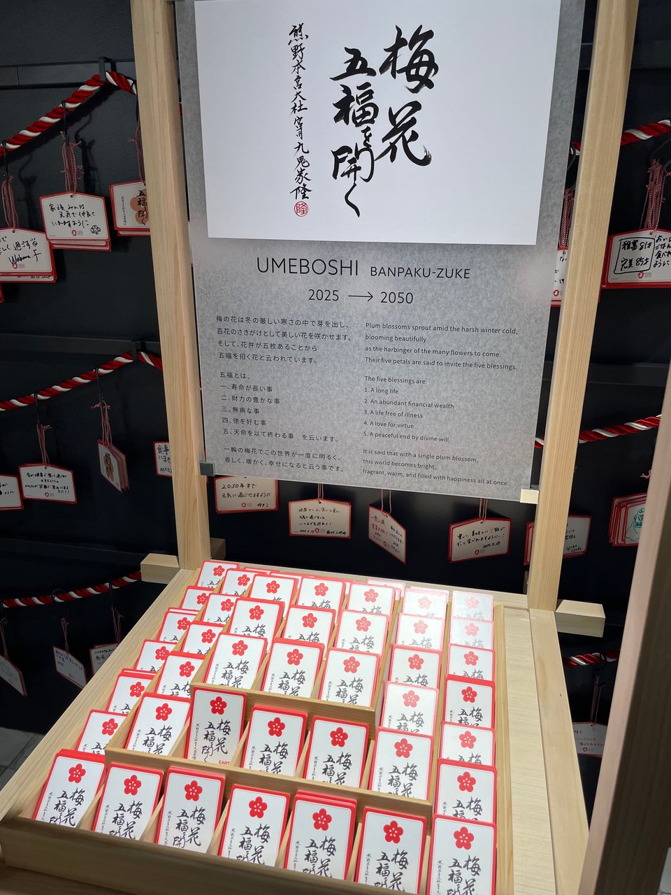 A display lined with red cards for redeeming your Banpaku-zuke umeboshi, or Expo umeboshi pickles.