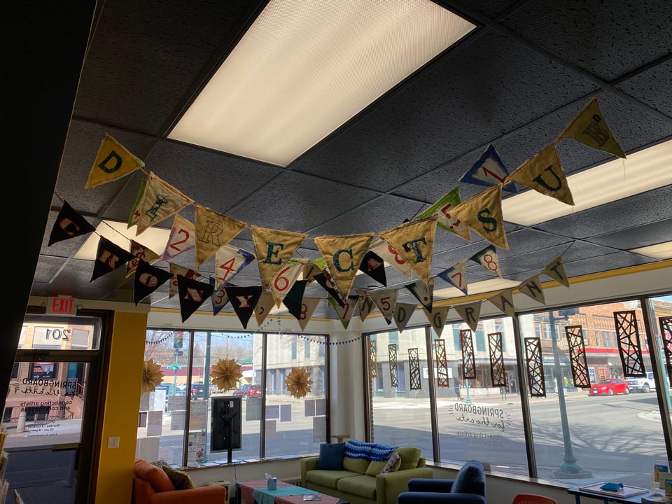interior installation view of banners hanging in office space from the other side