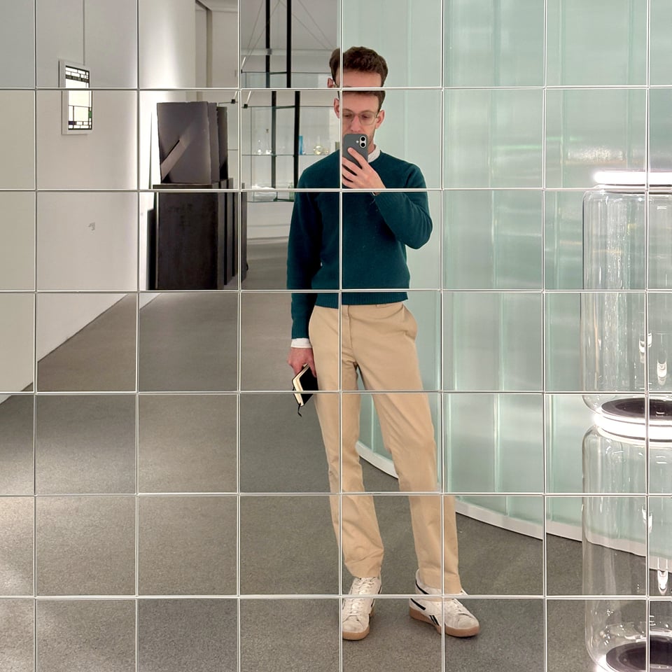 Photo of me in front of a square-tiled mirror wall