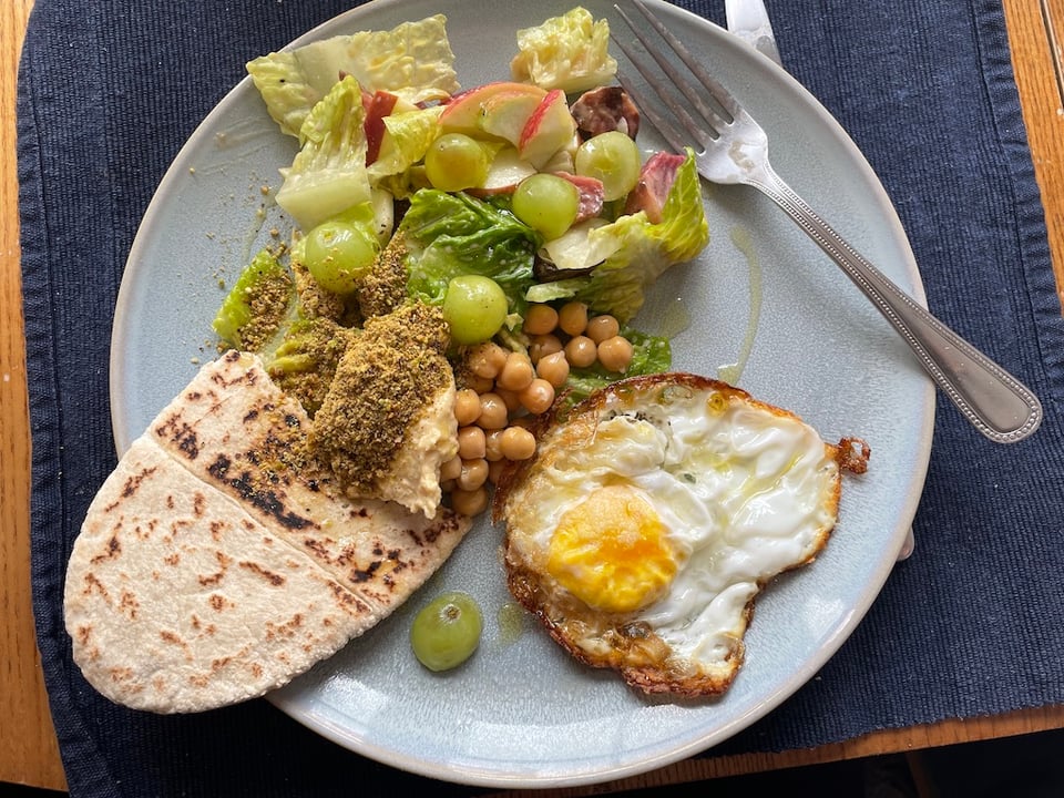 Salad, pitta, fried egg on a plate