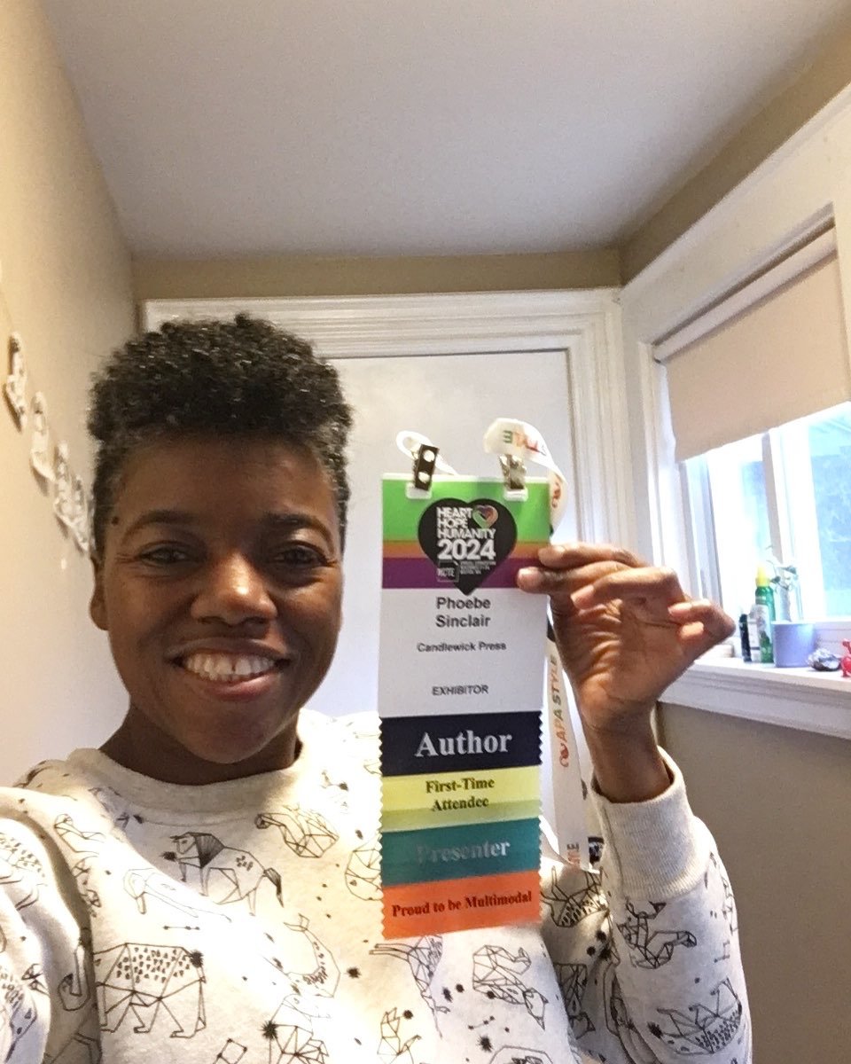 Phoebe holds up conference badge with ribbons