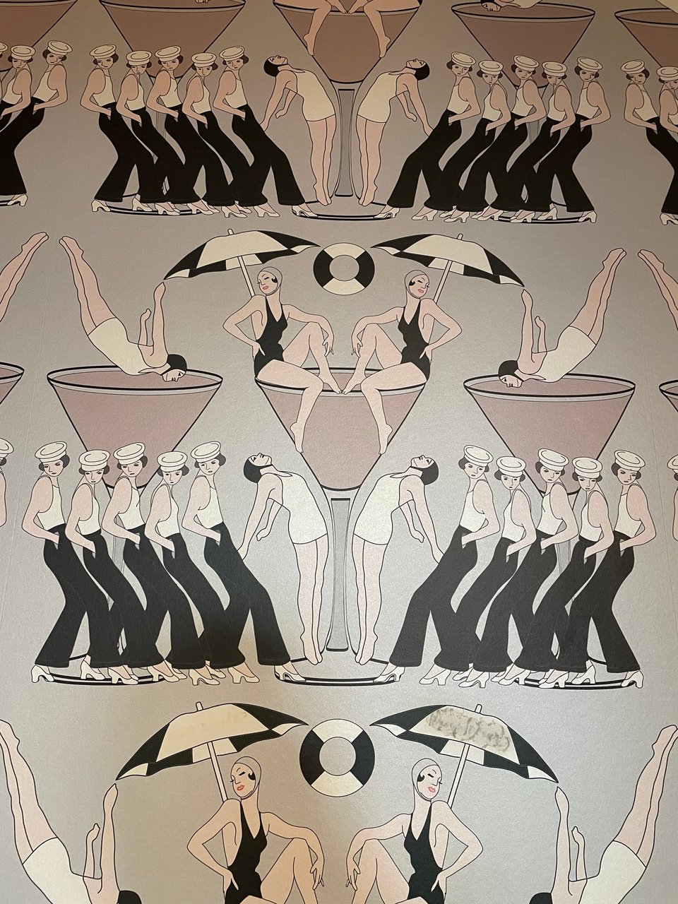 Art deco wallpaper of 1920s women in bathing suits posing and diving into cocktail glasses