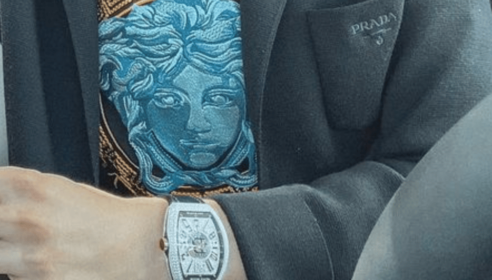 A watch is displayed, also some prada